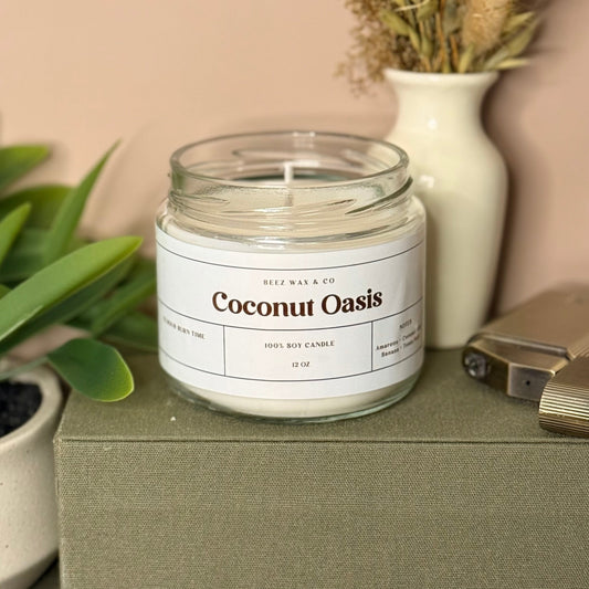 Coconut Oasis candle on a green box with a plant and lighter in the background
